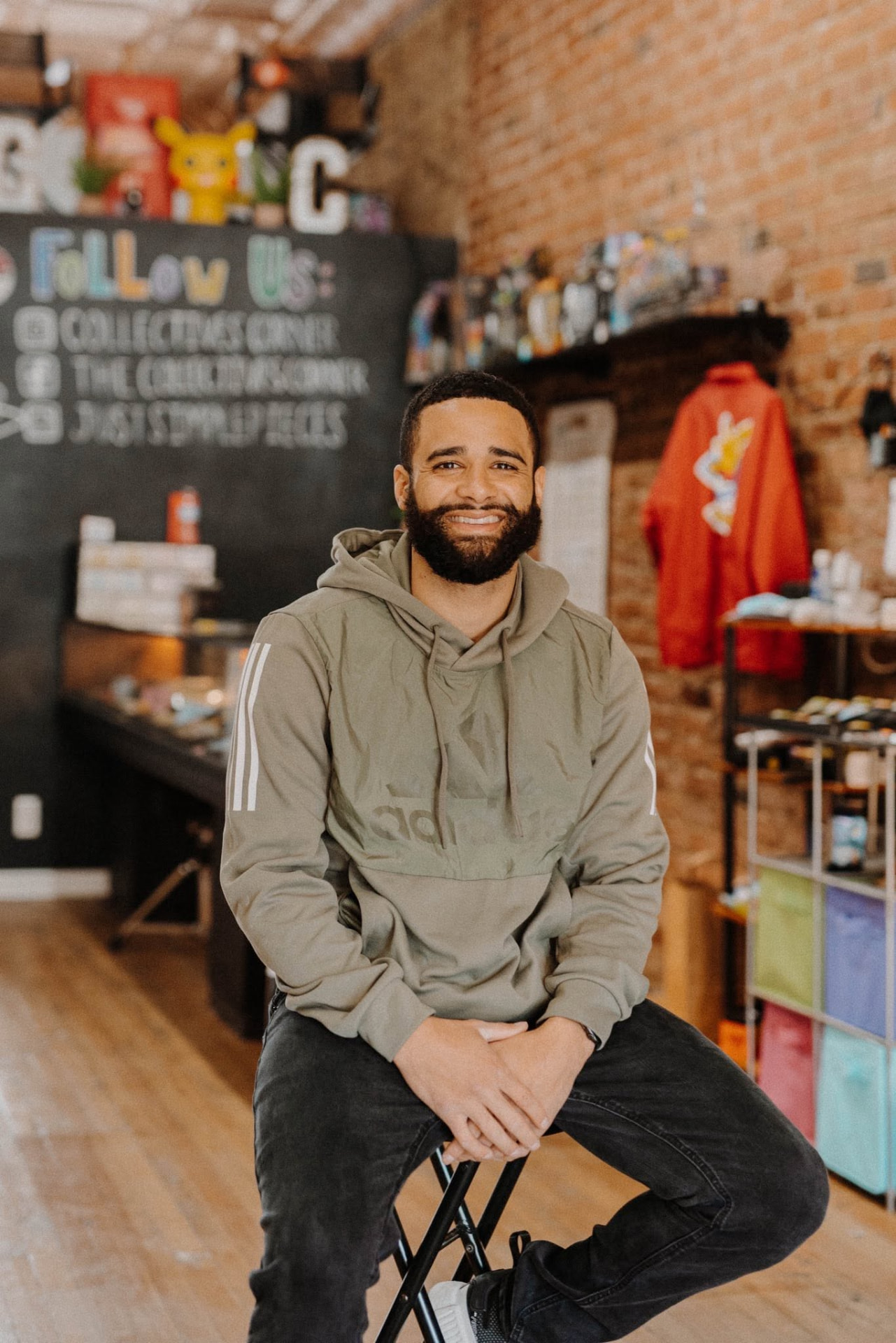 Devon Dupree seated in an Omaha shop with brick walls and shelves behind him