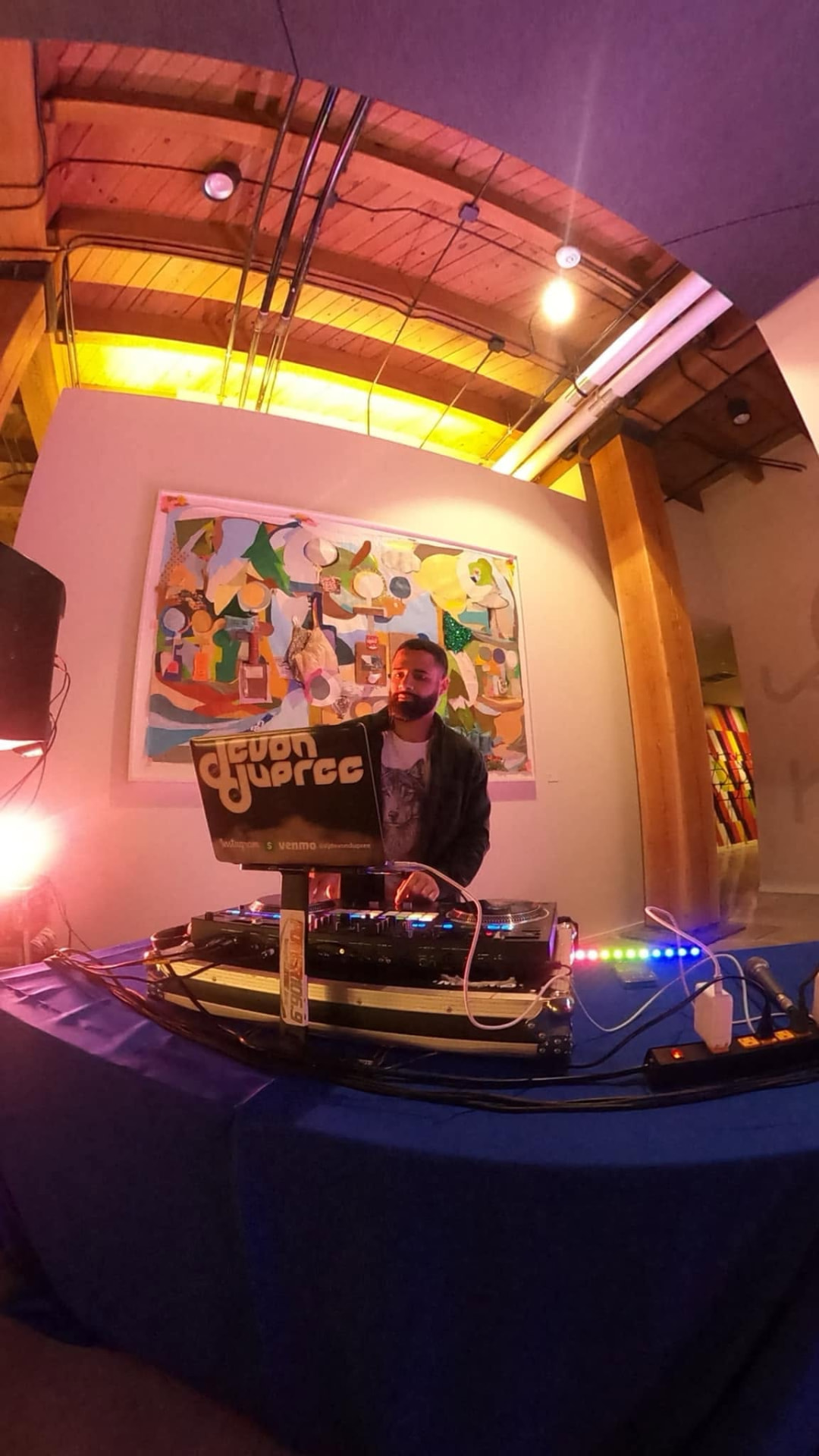 Devon Dupree performing a DJ set at an indoor Omaha venue with LED accent lighting
